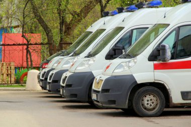 17-05-2020, Syktyvkar, Rusya. Rusya 'da bir şehir caddesinde kırmızı çizgili ve mavi ışıklı çok sayıda ambulans var.