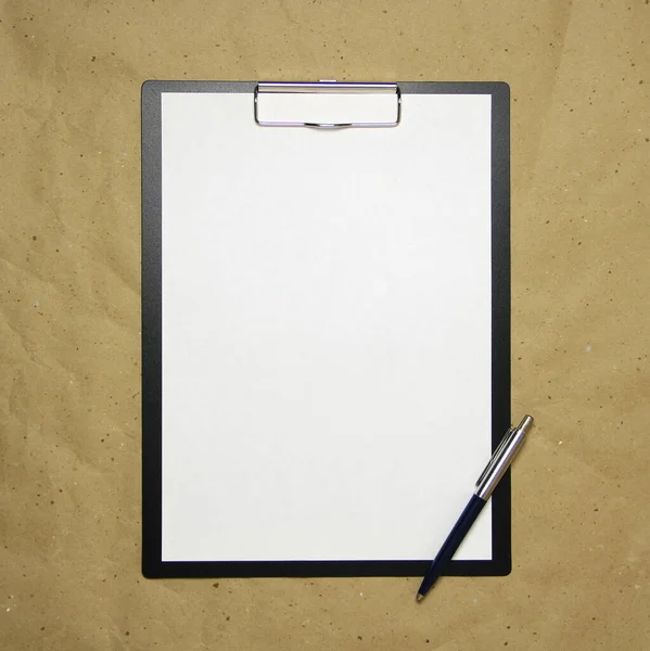 A4 formatında beyaz bir tablet. Bej renkli el işi kağıdında kalem var. Analiz anlayışı, çalışma, özenli çalışma. Metnin ve tasarımın için boş yeri olan stok fotoğrafı.