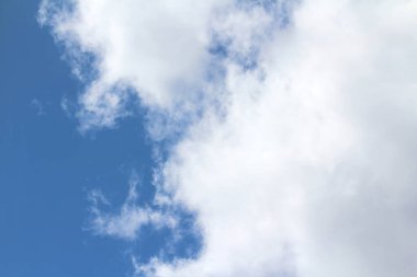 Yazın mavi gökyüzünün arka planında beyaz kabarık bulutlar. Hava ve iklim kavramı.