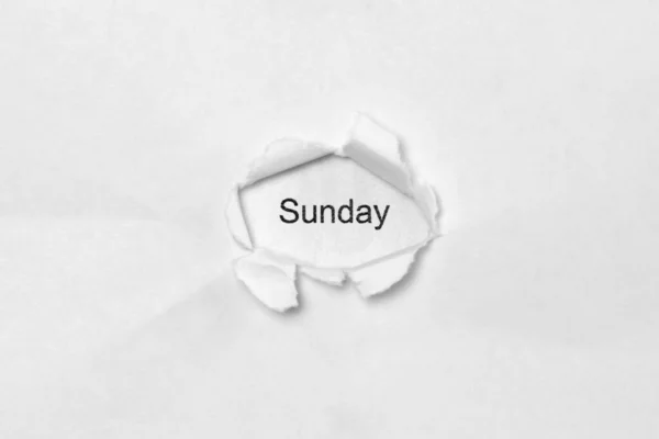 Слово неділя на білому ізольованому фоні через отвір рани в папері . — стокове фото