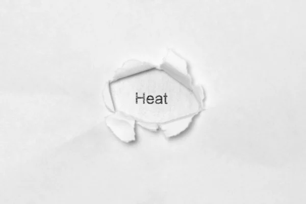 Λέξη θερμότητα σε λευκό απομονωμένο φόντο μέσα από την τρύπα πληγή στο χαρτί. — Φωτογραφία Αρχείου