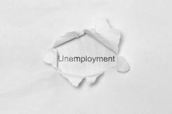 Word Unemployment on white isolated background through the wound hole in the paper. — Stock Photo, Image