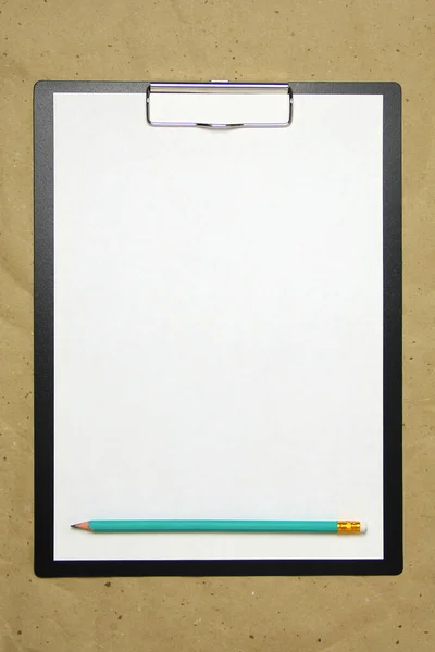 A tablet with a white sheet of A4 format on a beige craft paper. — Stock Photo, Image