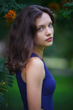 Girl in a blue dress walks in the park