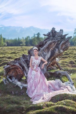 Kraliçe. Dağların arka planında bir kraliçe suretinde bir kız.