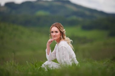 Gelin, dağların arka planında yürür, Altai 'de bir fotoğraf çekimi, gelinin bir portresi, beyaz elbiseli bir kız, boho tarzı.