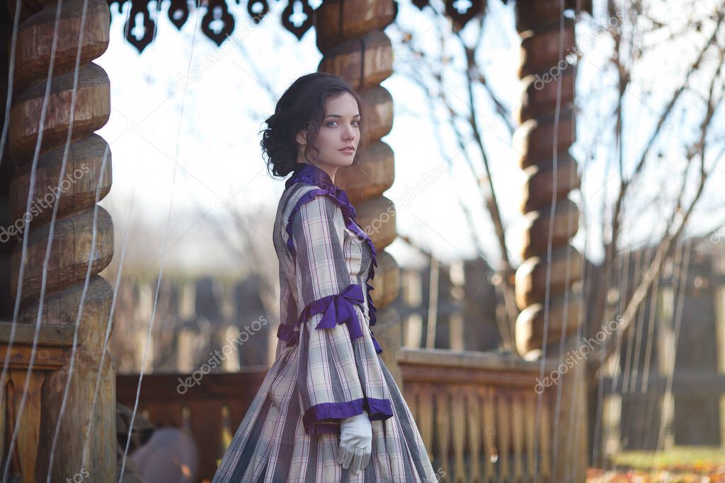 beautiful girl in a suit of the 19th century walks in the village