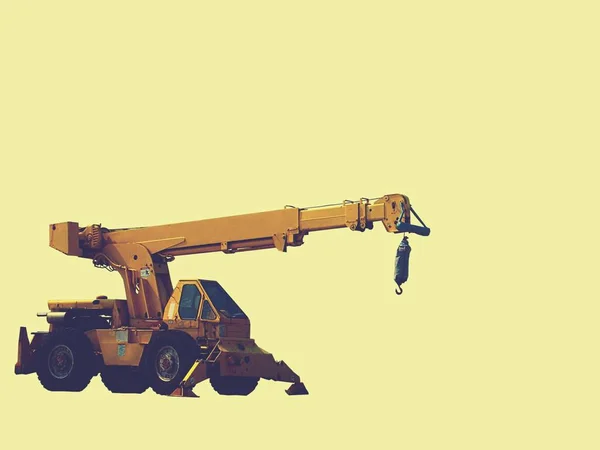 Construction backhoe with a pale yellow background — Stock Photo, Image