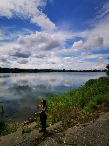 Une femme debout à côté d'un plan d'eau — Photo