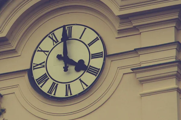 Часы, свисающие со стороны здания — стоковое фото