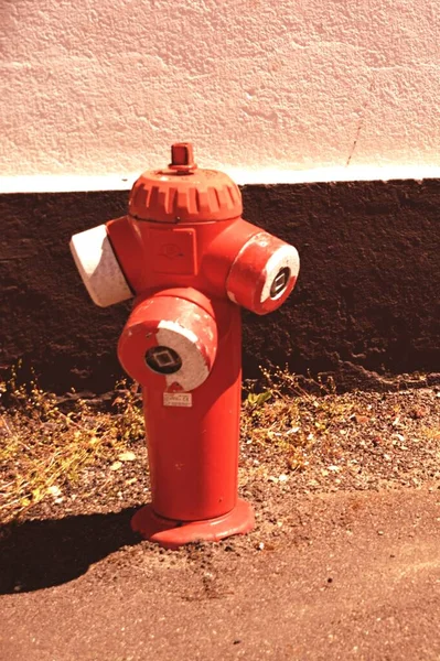 Um hidrante de fogo sentado ao lado de um edifício — Fotografia de Stock
