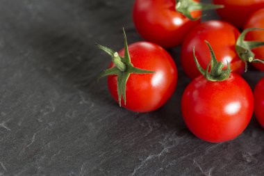 Siyah taş tahta üzerinde taze domates. 