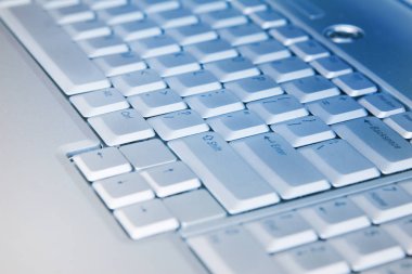 Gümüş dizüstü bilgisayar klavyesinin makro görüntüsü. Dizüstü bilgisayarın klavyesinin bir kısmının yakın plan resmi.