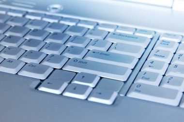 Gümüş dizüstü bilgisayar klavyesinin makro görüntüsü. Dizüstü bilgisayarın klavyesinin bir kısmının yakın plan resmi.