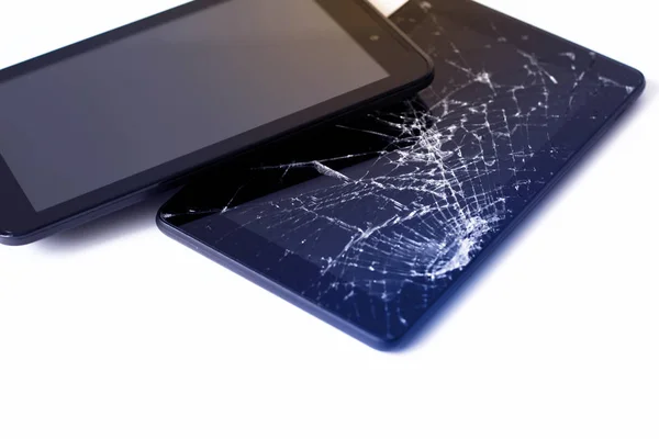 Фотографии взломанного дисплея на планшете и черного сотового телефона, изолированного на белом. Таблетки с поврежденным экраном . — стоковое фото