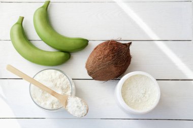 yeşil muz ve muz unu. Kavanozda hindistan cevizi ve un var. Beyaz ahşap bir masada glütensiz düşük karbonhidratlı un. metin için boşluk kopyala. glüten intolerans kavramı.