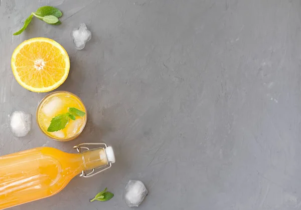 오렌지 주스를 얼음을 유리잔에 넣는다 오렌지와 칵테일 여름뜨거운 과회색 위에서 — 스톡 사진