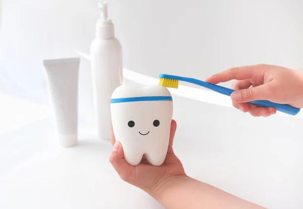 Niña limpieza juguete diente con cepillo de dientes . — Foto de Stock