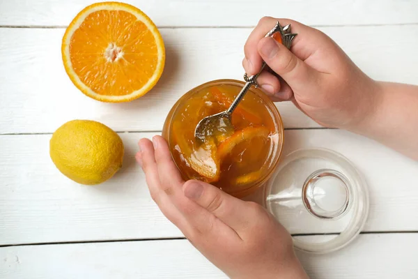 Adolescentes manos sosteniendo una cuchara con mermelada de naranja y limón —  Fotos de Stock