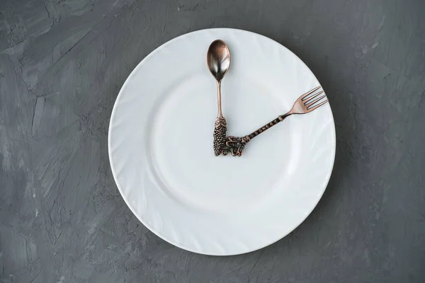 Conceito de hora de almoço. colher e um garfo em uma chapa — Fotografia de Stock