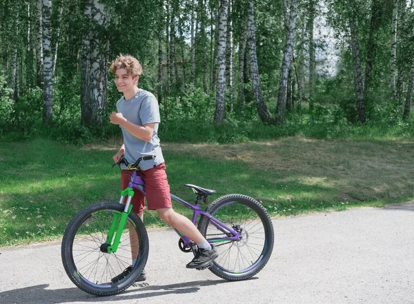 Heureux sourire adolescent garçon sur un vélo. — Photo