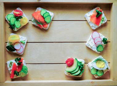 Yaz partisi için farklı sandviçler. Sağlıklı pirinç ekmeği, keçi peyniri ve çeşitli malzemelerle. Tütsülenmiş somon ve avokado, yumurta ve domates, metin için kopyalama alanı