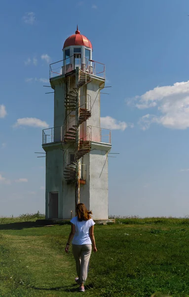 Frau kommt zu einem alten verlassenen Leuchtturm — Stockfoto