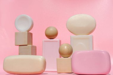 Pembe arka planda moda sabun dizaynı. Doğal sabun barları, tahta küpler ve toplar. Temizlik ve hijyen. Kişisel bakım konsepti. spa tedavisi.