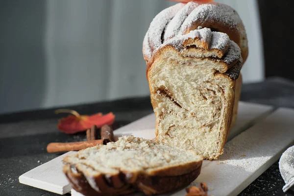 pull apart cinnamon swirl bread on wooden rack. cut of autumn traditional sweet loaf bread with cinnamon and powdered sugar. spicy baked bread. fall season pastry. selective focus