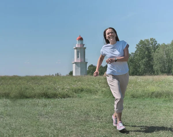 Happy Caucasian Woman Running Viewer Green Meadow Old White Lighthouse — Stock Photo, Image