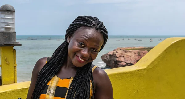 ガーナのアクラ海岸の階段の色と一致するカラフルな服を着たアフリカの幸せな女性 — ストック写真