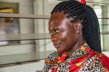 Afrikalı bir kadın otobüs durağında oturmuş otobüsünü bekliyor. Konum Accra Gana Batı Afrika