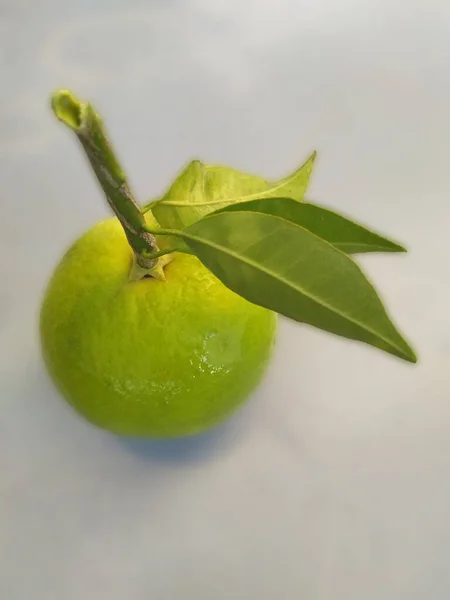 Beyaz arkaplanda yaprakları olan bir portakal.