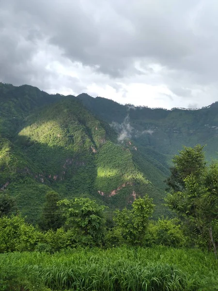 dağlar ve yeşil vadi kaplı ağaçlar ve gökyüzü bulutlu
