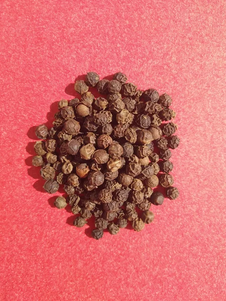 Doku arka planında üstten kara biber tohumları yığılıyor