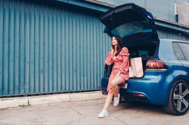 mavi bir araba ile elinde paketleri ile shooping gelen seksi giyinmiş ve giyinmiş bir genç kız