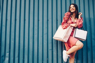 Güzel bir bayan ve gülümseyen, o moll gelen shooping paketleri ile birlikte geliyor. Alışveriş merkezinde indirimler.