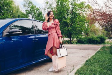 Güzel bir bayan ve gülümseyen, o moll gelen shooping paketleri ile birlikte geliyor. Alışveriş merkezinde indirimler.