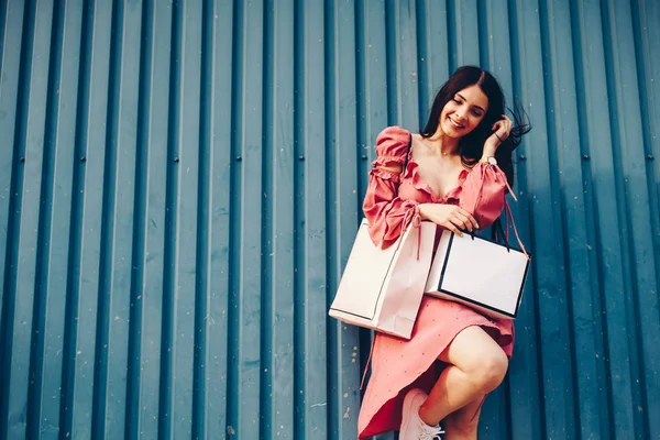 Güzel bir bayan ve gülümseyen, o moll gelen shooping paketleri ile birlikte geliyor. Alışveriş merkezinde indirimler.