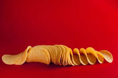 Lezzetli patates cipsi, kırmızı arka plan üzerinde izole.