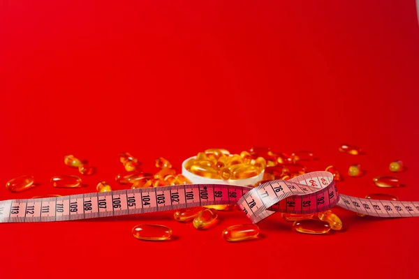 Kırmızı masaya dağılmış beyaz haplar. Reklam, web arka plan veya diğer fikirler gibi özel teklifler için alay. Tıp, eczacılık ve sağlık konsepti. Kopya alanı. Metin veya logo için boş yer.