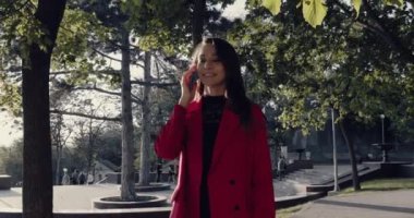 Kadın karşıdan karşıya geçerken akıllı telefonu tutuyor ve yan bakıyor..