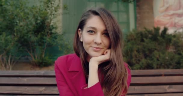 Retrato al aire libre de una hermosa mujer joven mirando a la cámara . — Vídeos de Stock