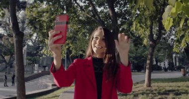 Parkta cep telefonuyla dikilen Avrupalı Kadın, Mesajlar Yazıyor.