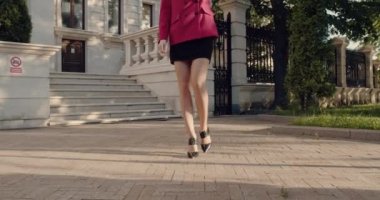 Kadın karşıdan karşıya geçerken akıllı telefonu tutuyor ve yan bakıyor..