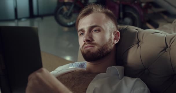 Um vídeo de perto de um homem barbudo que está lendo um livro interessante — Vídeo de Stock