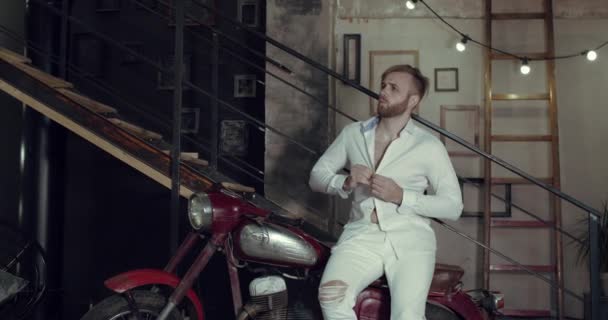 앉아 있다가 낡은 오토바이를 타고 춤을 추는 잘생긴 남자 — 비디오