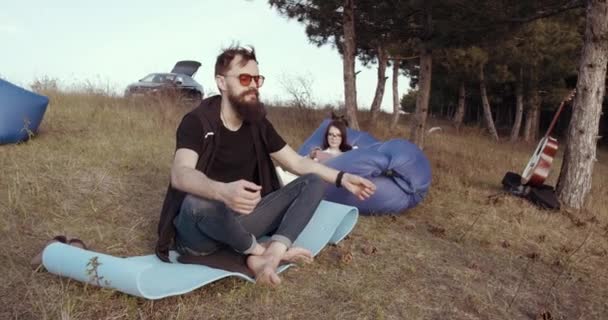 Um cara bonito está meditando na natureza — Vídeo de Stock