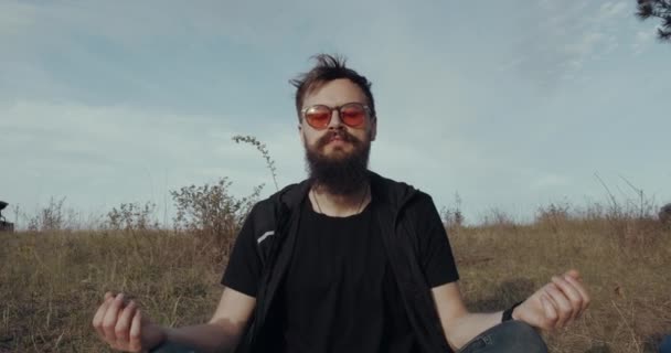 Um vídeo de perto de um hipster que está meditando na natureza — Vídeo de Stock