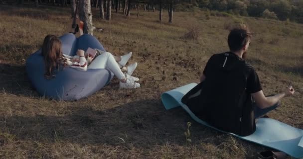 Um hipster está meditando na natureza — Vídeo de Stock